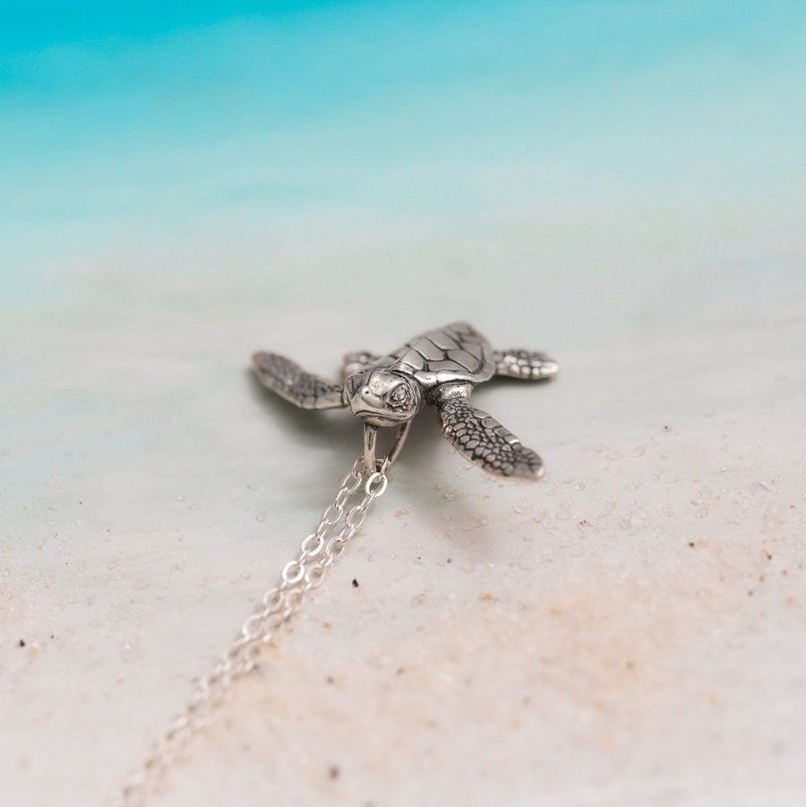 Collar Tortuga Bebé detalle en playa